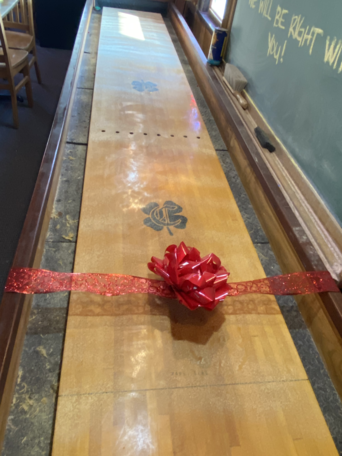 champions pub shuffleboard with bow on it